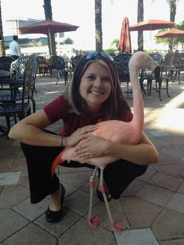 Shiloh Keuler holding a pink flamingo as a zookeeper