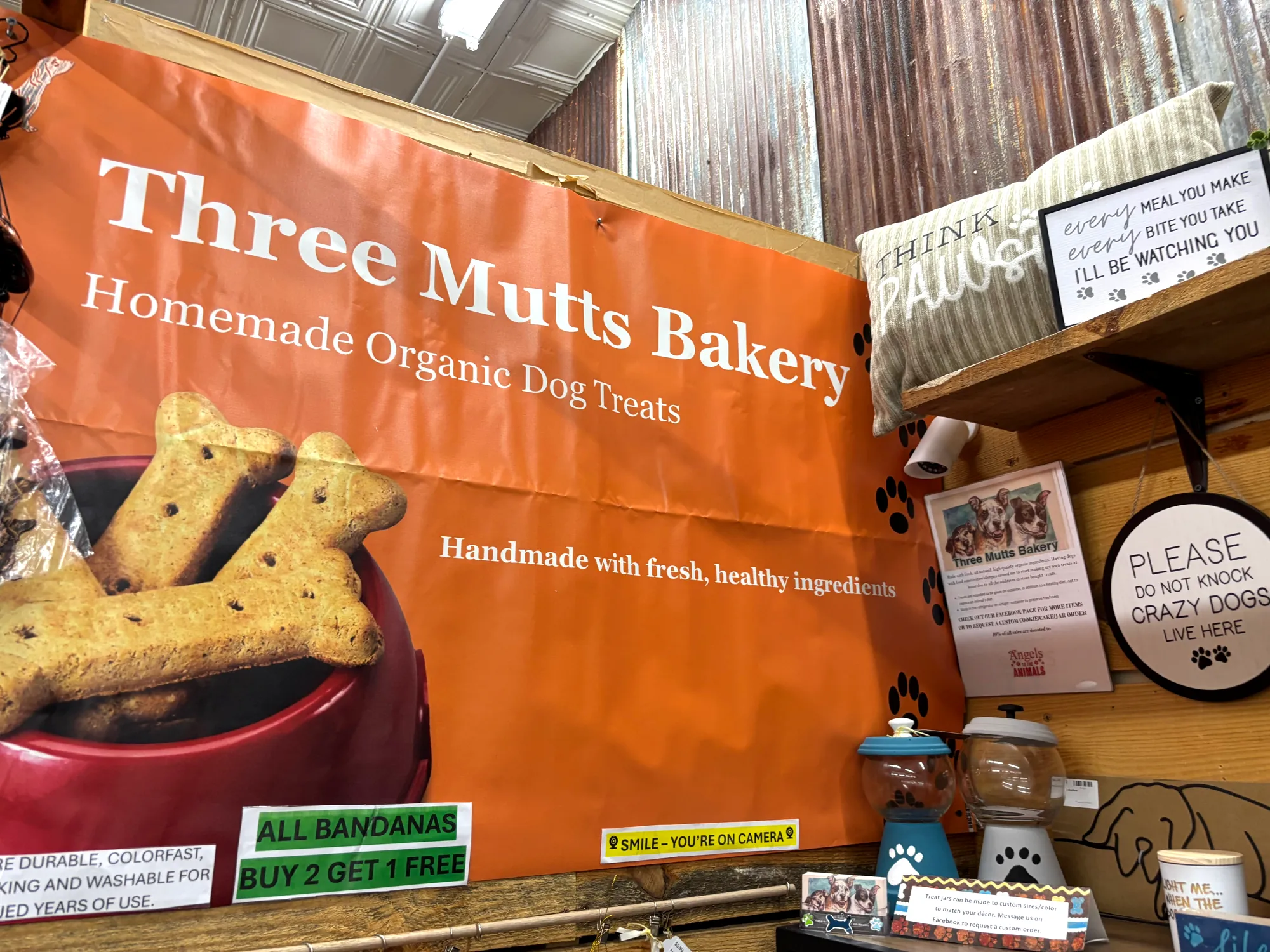 The orange Three Mutts Bakery banner and bone treats display at the booth inside Just Around The Corner in Lincolnton NC